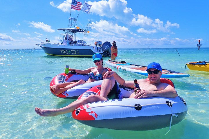 People sitting in inner tubes in clear blue water